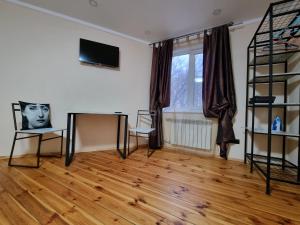 sala de estar con suelo de madera y TV en ARTAPARTMENTS-center en Chernihiv