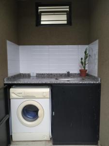 a kitchen with a washing machine and a sink at Casa 4 amb y cochera Don Bosco in Córdoba