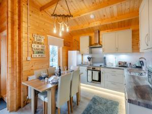 cocina y comedor con mesa y sillas en Seashell Lodge, en Gairloch