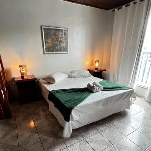 a bedroom with two beds and two lamps on tables at Pousada My House Arraial do Cabo in Arraial do Cabo