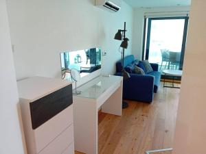 een woonkamer met een wit bureau en een blauwe bank bij Urban Oasis at Luxurious Ocean Village in Gibraltar