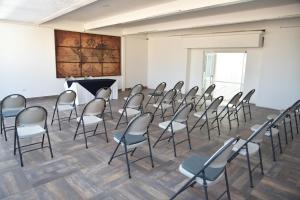 an empty room with chairs and a grand piano at Hotel del Arte y Figura in León