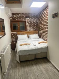 a bedroom with a large bed in a brick wall at GRAND BELLA VİSTA Hostel in Istanbul