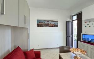 a living room with a red couch and a table at Nice Apartment In Marzamemi in Marzamemi