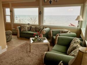 a living room with couches and a view of the ocean at Chesapeake Bay Maryland Waterfront Home, Stunning Views 45 min from DC pier fossils hiking in Port Republic