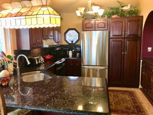 a kitchen with a sink and a stainless steel refrigerator at Chesapeake Bay Maryland Waterfront Home, Stunning Views 45 min from DC pier fossils hiking in Port Republic