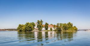 a house on an island in the middle of the water at UNiQE I 95qm I Bergblick I Garten I BBQ I seenah in Prien am Chiemsee