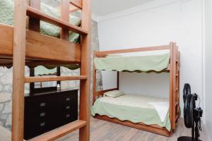 a bedroom with two bunk beds in a room at El Remate Panoramic View House 3 Levels Peten in Jobompiche