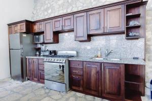 una cucina con armadi in legno e piano cottura. di El Remate Panoramic View House 3 Levels Peten a Jobompiche
