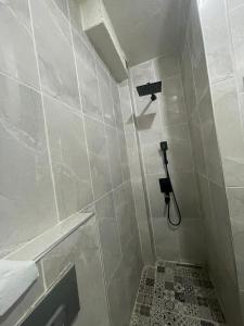 a white tiled bathroom with a shower and a sink at GRAND BELLA VİSTA Hostel in Istanbul