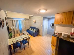 eine Küche und ein Wohnzimmer mit einem blauen Sofa in der Unterkunft THE LOOP 2br fully furnished corner unit w balcony in Cagayan de Oro