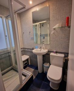 a bathroom with a white toilet and a sink at Estepona playa in Estepona