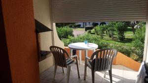 een kleine tafel en 2 stoelen op een balkon bij Résidence Parc Et Avenue Dominica - 2 Pièces pour 4 Personnes 324 in Le Barcarès