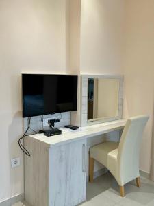 a desk with a television and a chair in a room at Kristal Garni Hotel in Novi Sad