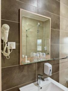 諾維薩德的住宿－Kristal Garni Hotel，一间带水槽和镜子的浴室