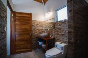 a bathroom with a toilet and a sink and a window at Lodge Las Estrellas de Samara - Ocean View in Sámara +58 photos