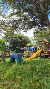 a playground with a slide in the grass at Casa Dohko 11 in Bogotá