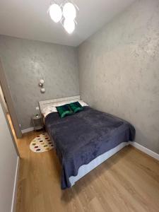 ein Schlafzimmer mit einem Bett mit einem grünen Kissen darauf in der Unterkunft Apartamenty Alexa Tatarska B in Przemyśl