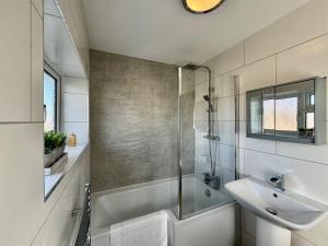 a white bathroom with a sink and a shower at Sandringham House - Serene Escape Cottage in Cleethorpes