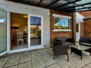 a patio with a couch and chairs and a table at Sandringham House - Serene Escape Cottage in Cleethorpes