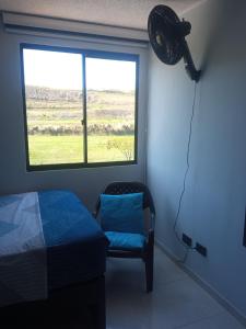 Zimmer mit einem Ventilator, einem Bett und einem Fenster in der Unterkunft Hospédate cerca al aeropuerto Matecaña in Pereira