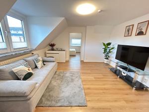 a living room with a couch and a flat screen tv at Zentrale Wohnung I 5G Internet I Netflix I in Iserlohn