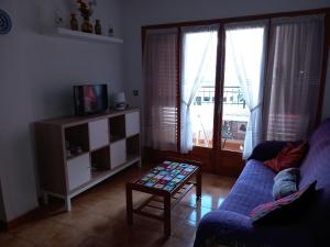 a living room with a blue couch and a tv at Apartamento Santa Pola, en Playa del Tamarit con piscina. in Santa Pola