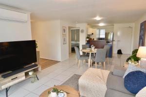 a living room with a couch and a tv at City Stadium Apartment 3 in Townsville