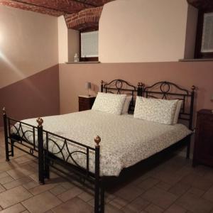 1 dormitorio con cama negra y almohadas blancas en OstellOrto en San Martino Canavese