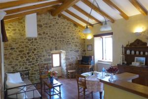 加爾的聖讓的住宿－La Clède de Monéry，一间厨房和带石墙的用餐室