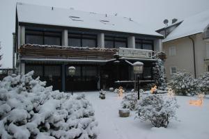 a building with snow covered bushes in front of it at Parkhotel Framke in Ehlscheid