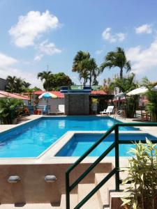 una piscina en un complejo con palmeras en El Remanso en Tonsupa