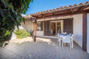 Un patio con una mesa y sillas en un patio. en Maison Elirè - 10 passi dal mare, en Capoliveri
