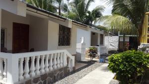 a white house with a staircase and palm trees at El Remanso in Tonsupa