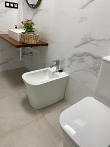 Baño blanco con lavabo y aseo en Victoria Beach Premium, en Málaga