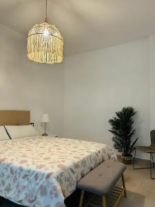 1 dormitorio con cama y lámpara de araña en Victoria Beach Premium, en Málaga