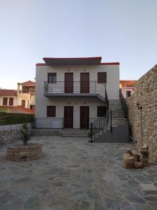 a white house with a balcony and a stone wall at Boutique At Historic Centrum 2 in Ioannina