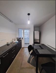 a kitchen with a table and a dining room at Apartment Iris bedroom living and parking voucher vacanță in Baia Mare