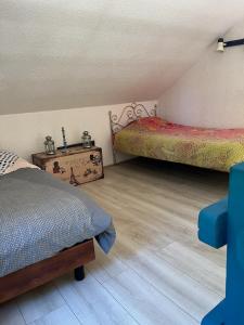 een slaapkamer met 2 bedden en een houten vloer bij La Faisanderie in Saint-Florent-sur-Cher