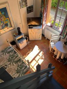 mit Blick auf ein Wohnzimmer mit einem TV und einem Tisch in der Unterkunft La Faisanderie in Saint-Florent-sur-Cher