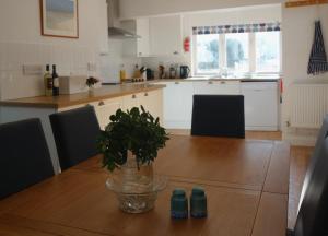 a kitchen with a wooden table with a plant on it at 10 Yards from Sea Hightide – Own Access to Beach in Sheringham