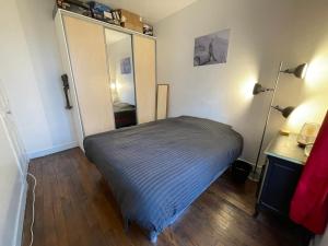 een kleine slaapkamer met een bed en een kast bij Apt 4personnes idéal pour les JO in Boulogne-Billancourt