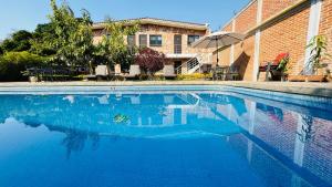 a swimming pool with blue water in front of a building at Hotel Villa Pralaya in Jiutepec