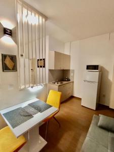 une petite cuisine avec une table et une chaise jaune dans l'établissement Studio apartment with pool, à Pula
