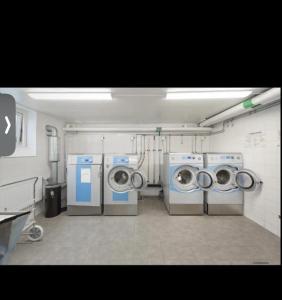a laundry room with three washing machines in it at Centralt i Malmö in Malmö