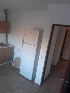 a white refrigerator in a kitchen next to a door at King srl in Craiova