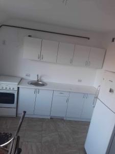 a kitchen with white cabinets and a sink at King srl in Craiova