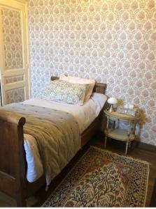 sypialnia z łóżkiem i stołem z dywanem w obiekcie Château de la Franceule - la petite w mieście Janzé