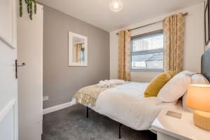 een slaapkamer met een bed en een raam bij Belfast City Centre & allocated Parking by StayByNumbers in Belfast