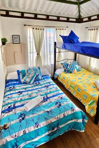 dos camas sentadas una al lado de la otra en un dormitorio en Madre Tierra- Casa hospedaje en Villa de Leyva